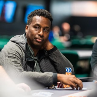 image of a man smiling while sitting at a poker table